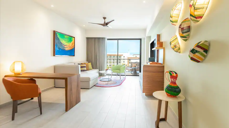 Living room with workspace and balcony access in the Club One Bedroom Master Suite at Hyatt Ziva Cap Cana.