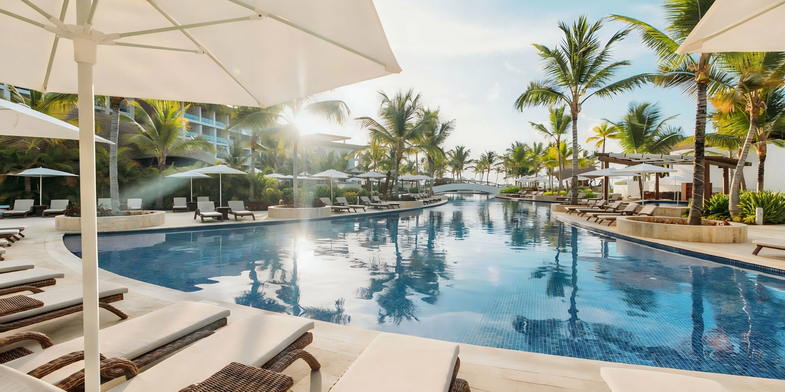 Infinity-style swimming pool at Hyatt Ziva Cap Cana with sun loungers, umbrellas, and tropical beachfront surroundings.