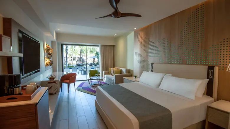 Junior Suite Swim-Up King living area with king bed and poolside terrace at Hyatt Ziva Cap Cana.